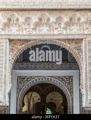 Royal Alcazar carved stucco arches aligned across a sequence of rooms with geometric wall decoration, Sevilla Stock Photo
