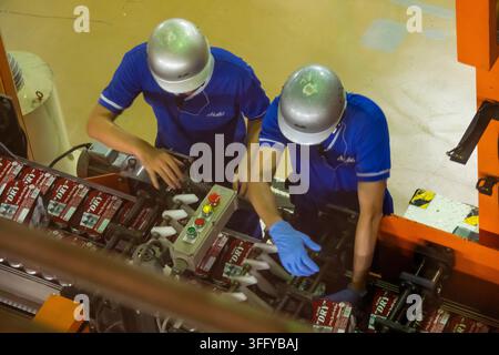 Row Line Enginering In a beverage factory line two engineers inspect product bottles on the ...