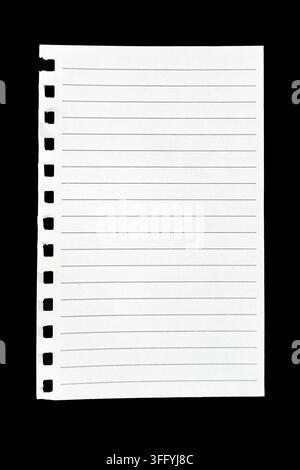 Torn sheet of blank lined notebook paper with spiral binding holes isolated against a black background. Stock Photo