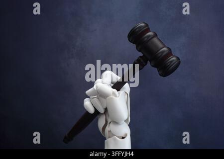 White robotic hand holding a dark wooden judge gavel. Artificial intelligence in law, automated court decisions concept. Stock Photo