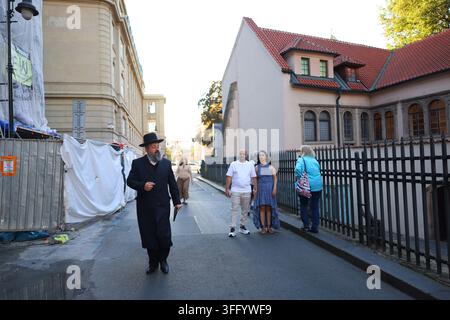 Prague, Czech Republic - August 31, 2026: Orthodox Jewish man in traditional clothing walking along a historic street in central Prague. Stock Photo