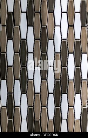 Geometric Mosaic Tiles in White Brown and Charcoal. Close view of glossy geometric mosaic tiles in white, beige, brown, and charcoal arranged in Stock Photo