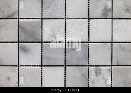 White and Gray Marble Square Mosaic Tile Grid. Close view of white and gray marble mosaic tiles arranged in a square grid pattern. Stock Photo