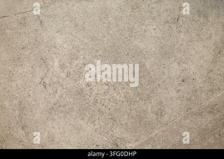 Beige Stone Texture with Fine Speckles and Scratches. Close-up of a beige stone surface with fine speckles, subtle scratches, and natural weathered Stock Photo