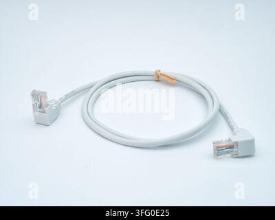 Ethernet Cable with Angled Connectors - A coiled white Ethernet cable with angled RJ45 connectors on a clean white background, ready for network conne Stock Photo