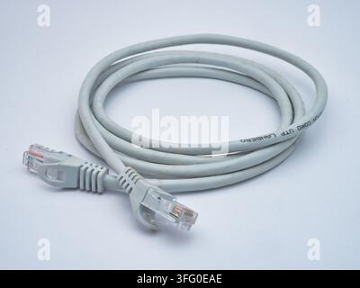 Grey Ethernet Cable with RJ45 Connectors - A coiled grey Ethernet cable with two RJ45 connectors on a clean white background, ready for network connec Stock Photo