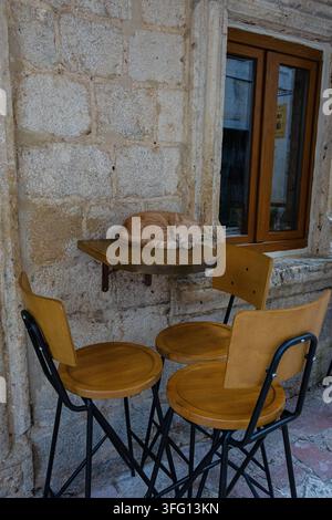 Sleeping orange cat resting on a cafe table in the historic Old Town of Kotor, Montenegro Stock Photo