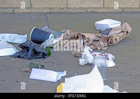 A pile of discarded single-use food packaging and litter scattered across a concrete sidewalk. Southport, UK. Stock Photo