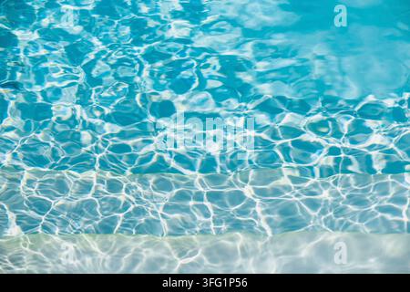 Sunlit pool water with gentle ripples reflecting light, creating a serene blue atmosphere Stock Photo