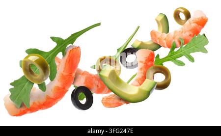 Shrimps, avocado pieces, arugula leaves and sliced olives flying in air against white background Stock Photo