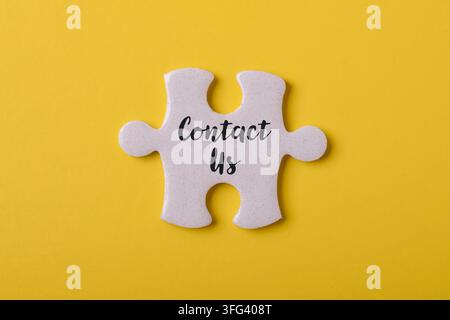 Single puzzle piece with contact us text symbolizing customer support, communication, business inquiries, help desk, and online assistance Stock Photo