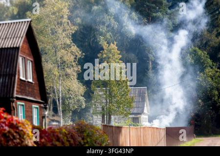 unextinguished fire and smoke in the neighbourhood , sunny day countryside scene Stock Photo