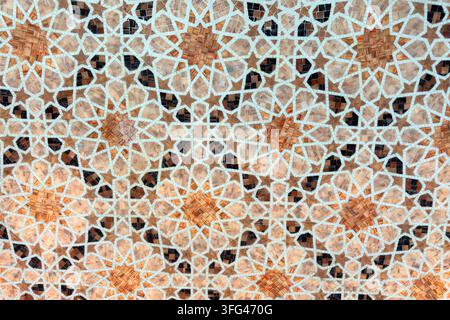 Traditional Islamic geometric mosaic pattern featuring floral motifs in warm beige and white tones. Decorative Middle Eastern ornament suitable for Stock Photo
