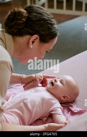 Mother Playing with Happy Baby Child at Home during Childcare Routine Stock Photo
