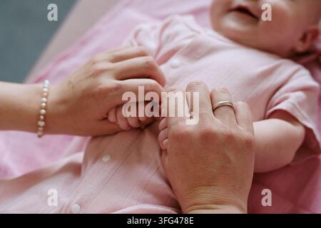 Mother Holding Hands of Baby Child for Family Care Concept Stock Photo