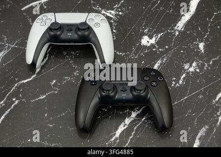 Bogota, Colombia - August 2026 Ps5 dualsense controllers in black and white on a marble background Stock Photo