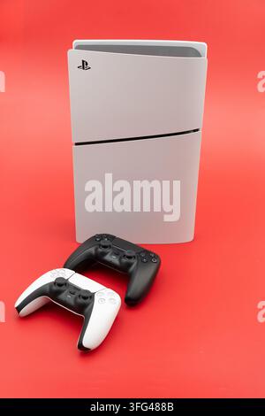 Bogota, Colombia - August 2026 Playstation 5 slim console standing with two dualsense controllers for gaming entertainment Stock Photo