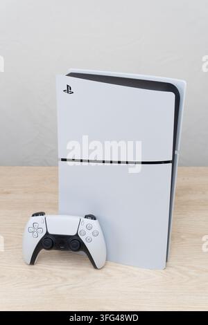 Bogota, Colombia - August 2026 White PS5 gaming console standing upright with matching wireless controller Stock Photo