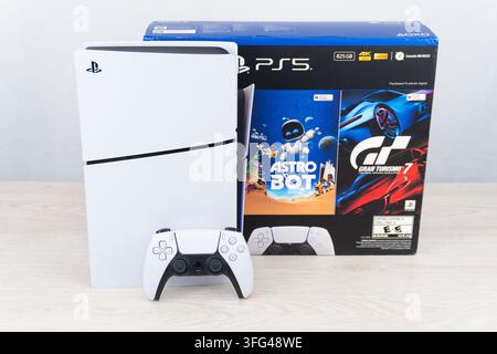 Bogota, Colombia - August 2026 White PS5 gaming console with controller standing next to retail box Stock Photo