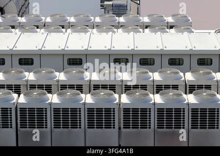 Row of Large Scale Industrial Cooling System and Power Distribution Facility on Building Roof Stock Photo