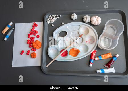 Painting clay pumpkins and colorful fall decorations on creative work tray Stock Photo