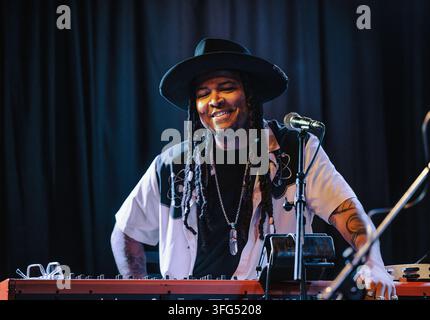 Happy musician with dreadlocks playing keyboard on stage Stock Photo