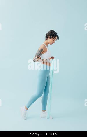 Full length of a young, slim woman practicing with a resistance band Full length of a young, slim woman practicing with a resistance band Russia Copyr Stock Photo