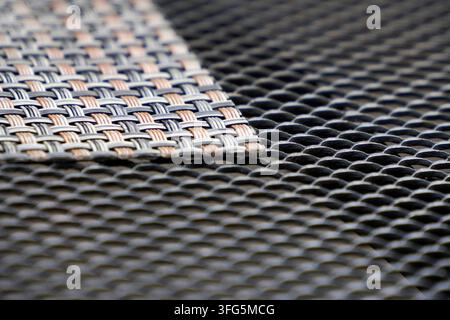 Macro shot of a silver expanded metal mesh surface showing diamond-shaped holes with shallow depth of field. Stock Photo