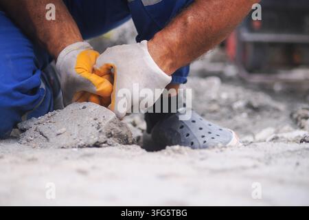 Worker lays concrete in construction site Stock Photo