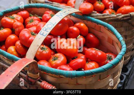 Fresh tomatoes in woven baskets at a market Stock Photo