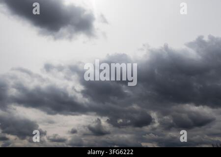 Dark storm clouds gather across a grey sky, creating a dramatic moody weather background with broad atmospheric copy space Stock Photo