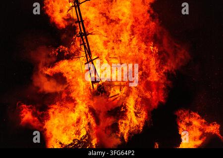 FACE OF FIRE AND DESTRUCTION, BURNING THE WICKER MAN EFFIGY, GREEN MAN FESTIVAL, BRECON, WALES, UK, 2016: In a chaotic swirl of fire, the burning wooden effigy seems to form a demonic face within the intense orange and red flames. Photo: Rob Watkins. INFO: The Green Man Festival is held annually in the Brecon Beacons in August. It celebrates music, arts, literature, science and family-friendly culture in a beautiful mountain setting. Each year the festival ends with the ritual burning of the wicker man Green Man effigy. Stock Photo