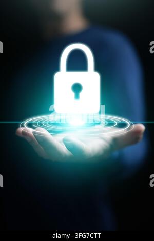 Cybersecurity concept, A man hand holding glowing padlock icon for system, data, or network protection, security, safety, and privacy on vertical dark Stock Photo