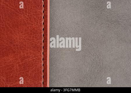 High contrast background showing brown stitched leather seam meeting smooth grey suede surface Stock Photo