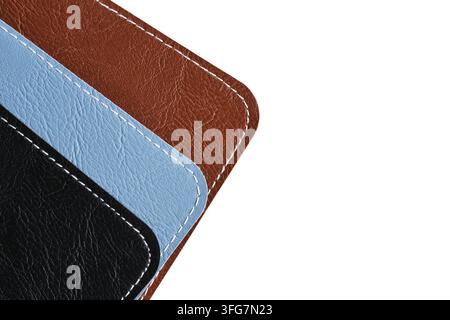 Top left corner close up brown, blue, and black stitched leather layers with copy space on white Stock Photo