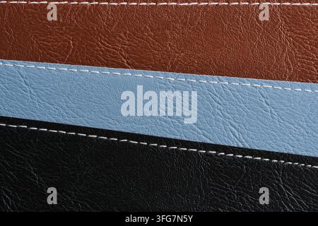 Horizontal macro background texture showing three stitched leather layers in brown, blue, and black Stock Photo