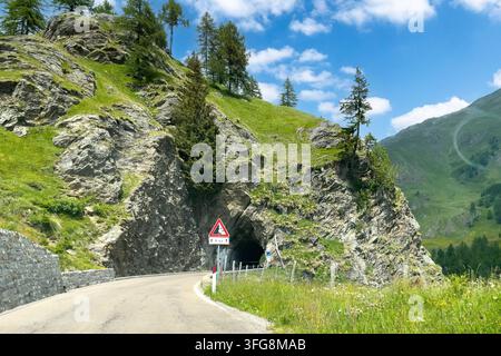 Mountain road in Alps leads through terrain with risk of rockfall Landslide as a result of global warming with extreme heat waves and erosions in rock Stock Photo