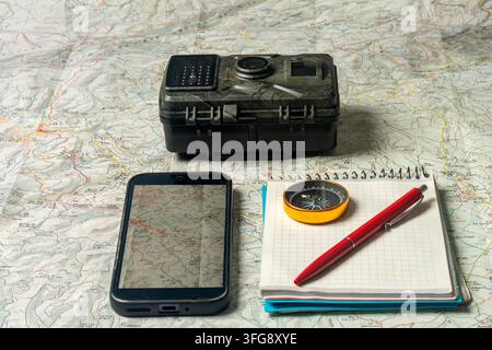 Planning wilderness adventure using map, compass, and digital devices Stock Photo