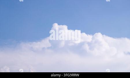 Towering White Cumulus Cloud Floating In Bright Blue Summer Sky Stock Photo