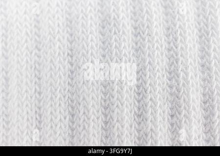 Close-up of knitted fabric with soft texture, possibly wool or synthetic blend, in a light gradient background, suitable for fashion, textiles, or hom Stock Photo