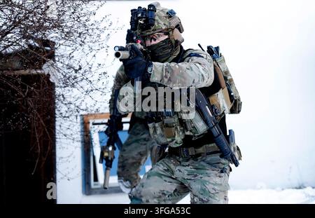 Fully equipped soldier (Forsvarets spesialkommando/FSK) in camouflage holding rifle during snowy winter operation Stock Photo