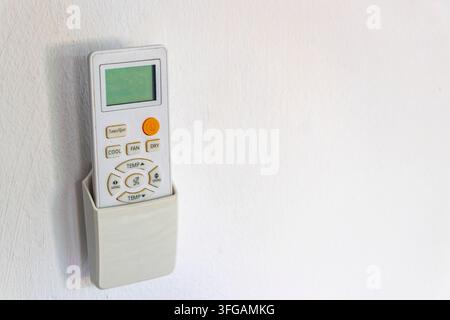 Air conditioner remote control in a wall holder ready for use in a Thai hotel room in Patong Beach Kathu District Phuket Island Province Southern Thai Stock Photo