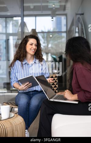 Women colleagues collaborating on project at office lounge Stock Photo