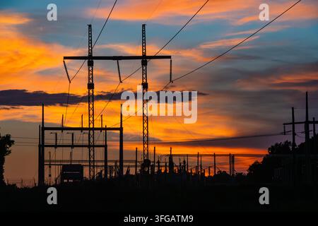 Electrical substation silhouetted against a colorful sunset sky. (USA) Stock Photo