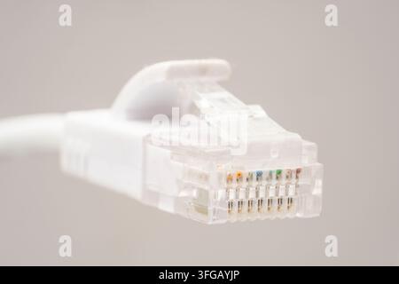 Close-up of a Cat 6A RJ45 LAN network ethernet cable connector plug with white body and clear latch on a white background Stock Photo