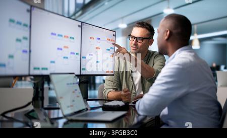 Business Analyst And Engineer Collaborate Optimizing Automated Workflow Efficiently. Stock Photo
