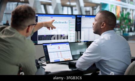 DevOps Engineer Monitors Pipeline Status On Laptop For Smooth Software Delivery. Stock Photo