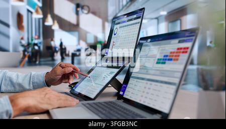 Data Scientist Carefully Reviews AI Risk Dashboard On Dual Touchscreen Laptops. Stock Photo