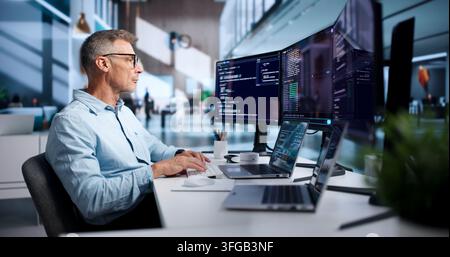 Software Developer Carefully Writing Code On Laptop In Cloud-based ...