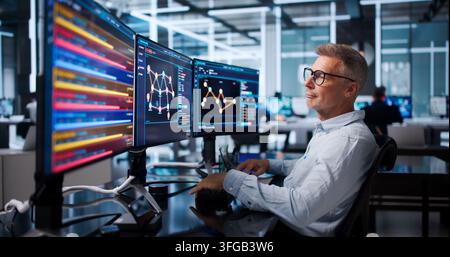 Senior Software Developer Pointing At Screen While Writing Efficient Code. Stock Photo